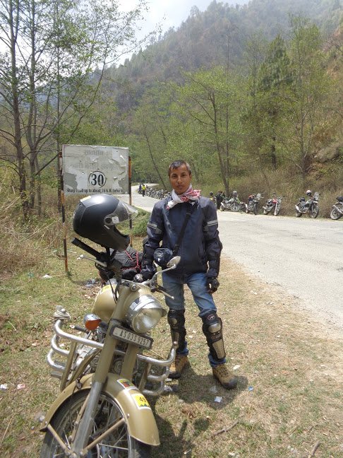 A rider standing nearby a royal enfield bike