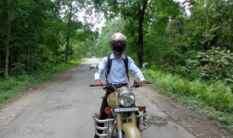 A rider with a Royal Enfield bike as seen from the front