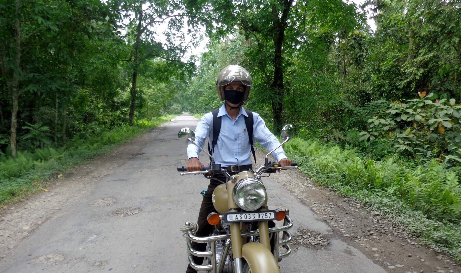 A rider with a Royal Enfield bike as seen from the front