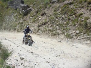 A rider trying to ride on a rough hilly road